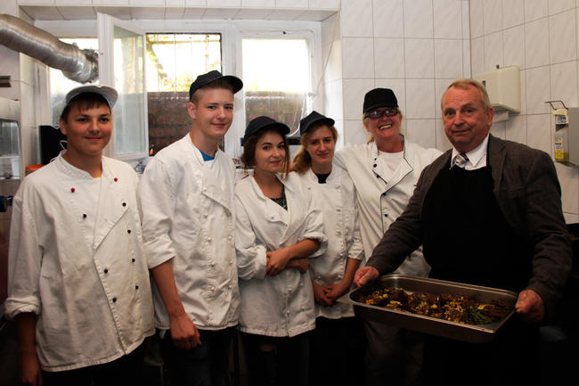 Till Backhaus und Köche mit den frisch zubereiteten Hirschsteaks