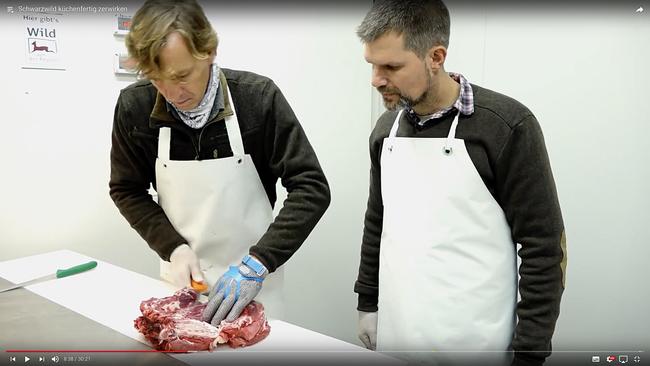 Wildmeister Christoph Hildebrandt (l.) zeigt DJV-Pressesprecher Torsten Reinwald, wie Wildschwein küchenfertig zerwirkt wird.