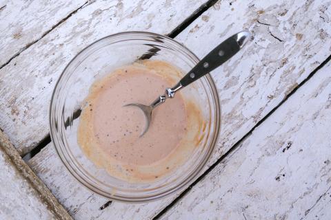 Die Mayonnaise mit dem Ketchup, Senf und Schmand verrühren. Mit Salz, Pfeffer und 1 EL Gurkenwasser aus dem Glas abschmecken. (Quelle: Ilka Dorn )