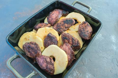 Apfelringe und Fleisch gleichmäßig verteilen. Sauce über das Fleisch gießen und zum Schluss geriebenen Käse darüber streuen. (Quelle: Dorn/DJV)