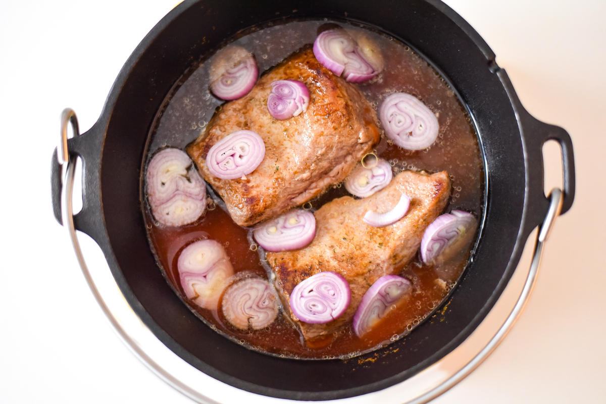 Das Wildschweinfleisch mit Salz und etwas Zucker würzen. Im DutchOven in Sonnenblumenöl rundherum anbraten. Hat das Fleisch gut Farbe genommen, den Wildfond, die klein geschnittene Zwiebel und die passierten Tomaten hinzugeben. Den Deckel verschließen und für zwei Stunden schmoren lassen. (Quelle: Kapuhs/DJV )