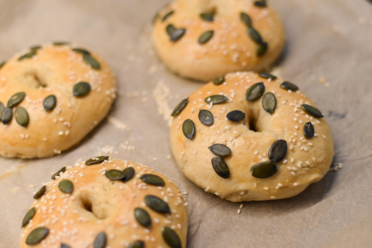 Anschließend die Bagel wieder auf das Backblech legen, mit einem verquirltem Ei bestreichen und mit Sesam und Kürbiskernen bestreuen. Nun im vorgeheizten Backofen bei 200 Grad Celsius Ober- und Unterhitze für zirka 25 Minuten backen. (Quelle: Kapuhs/DJV )