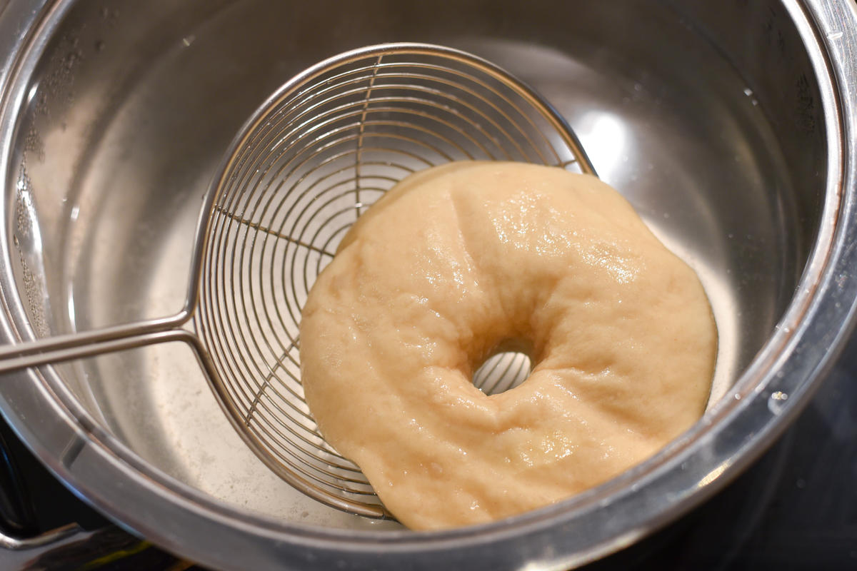 In einem großen Topf Wasser zum Kochen bringen. Sobald dieses kocht, den Topf beiseitestellen und die Bagel nacheinander für 30 Sekunden in das Wasser tauchen. (Quelle: Kapuhs/DJV )