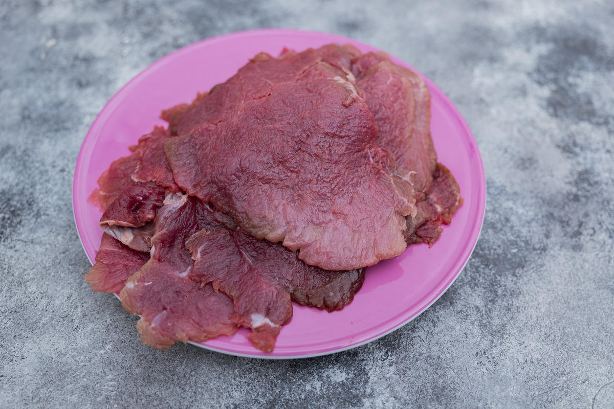 Wildschweinschnitzel zwischen zwei Lagen Frischhaltefolie schön dünn klopfen, salzen und pfeffern.  (Quelle: Dorn/DJV)