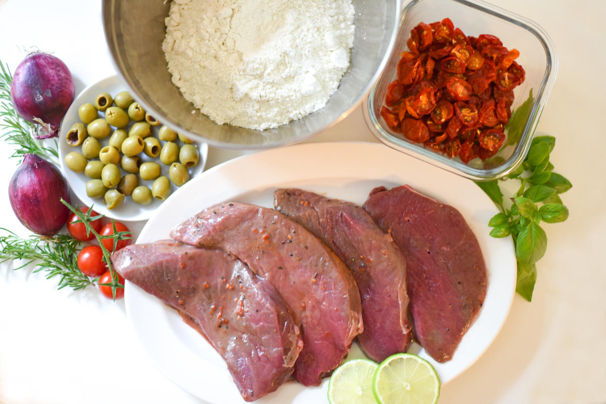 Die Hauptzutaten für das Rezept: marinierte Hirschsteaks, Mehl, getrocknete Kirschtomaten und Oliven. (Quelle: Kapuhs/DJV )