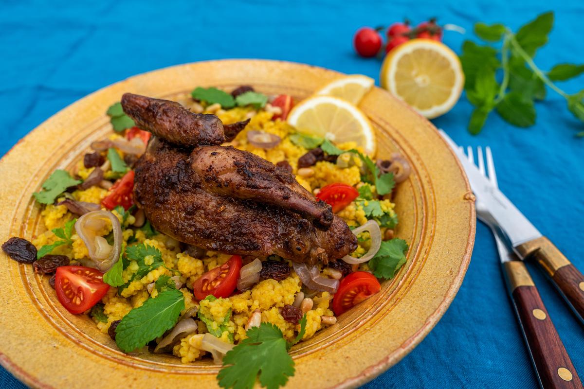 Couscous mit Pinienkernen und Tomatenwürfeln bestreuen und zusammen mit den Taubenhälften servieren. Mit Zitronenscheiben garnieren. (Quelle: Dorn/DJV)