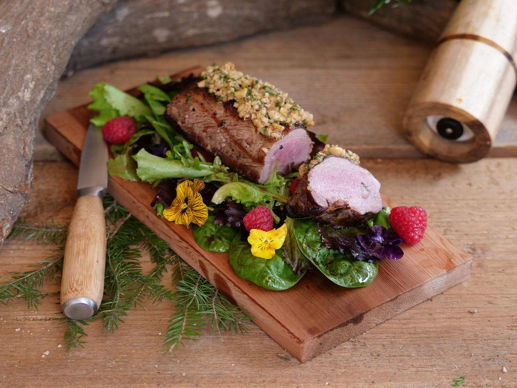 Geblankter Wildschweinrücken mit Nusskruste auf Wildkräutersalat ...