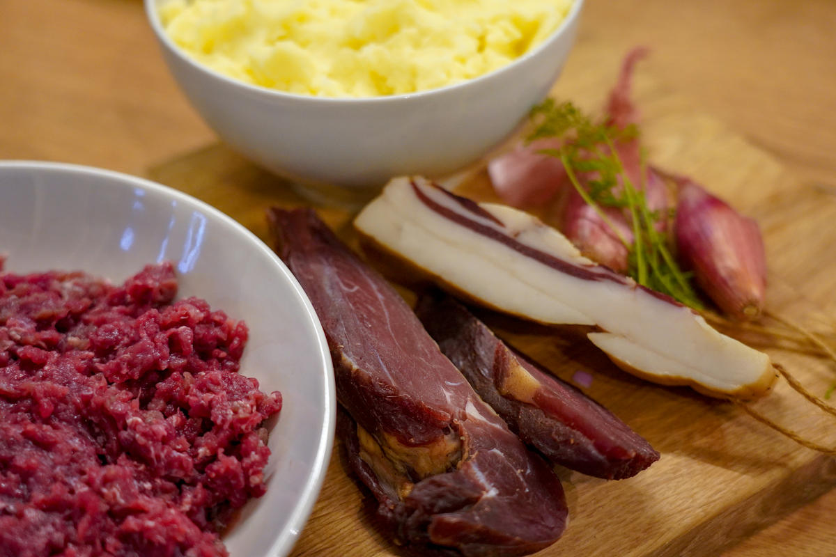 Die Hauptzutaten für das Rezept: Reh-Hackfleisch, Kloßteig, Wildschwein-Speck, Wildschinken und Schalotten. (Quelle: Kapuhs/DJV)