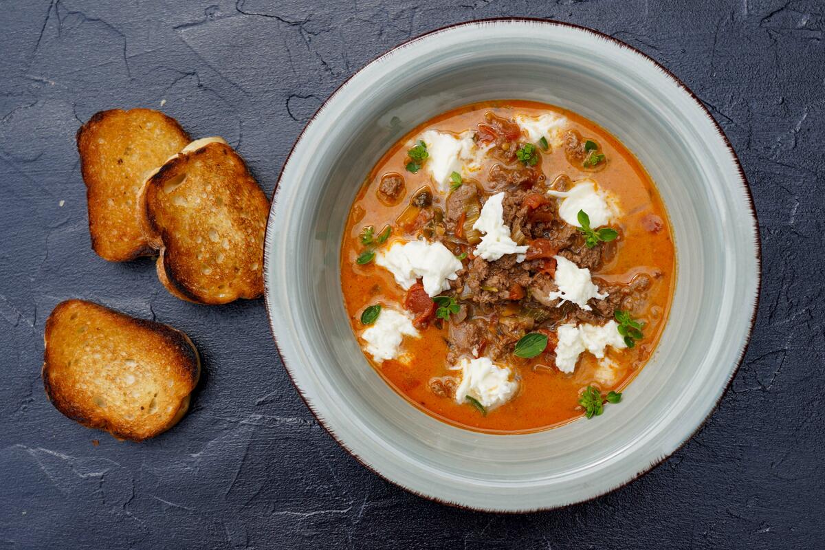 Die Suppe mit gezupftem Mozzarella und frischem Oregano verfeinern. Dazu passt geröstetes Brot.  (Quelle: Kapuhs/DJV )