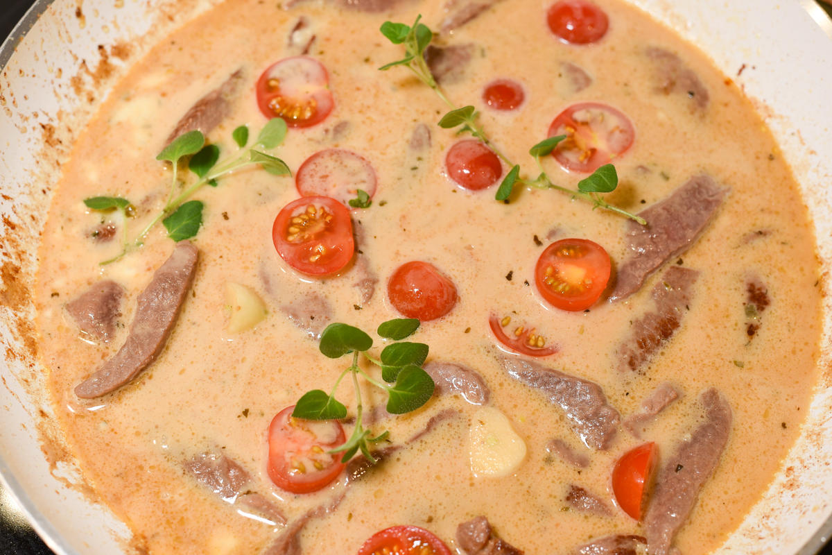 Nun scharf anbraten, mit Weißwein ablöschen und Creme Fraiche unterrühren. Tomaten, Knoblauch und Majoran dazugeben. (Quelle: Kapuhs/DJV)