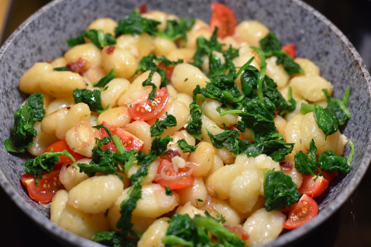 Die Gnocchi kochen, anschließend mit Zwiebeln und Speck anbraten. Später Blattspinat, Knoblauch und Tomaten untermischen (Quelle: Kapuhs/DJV)