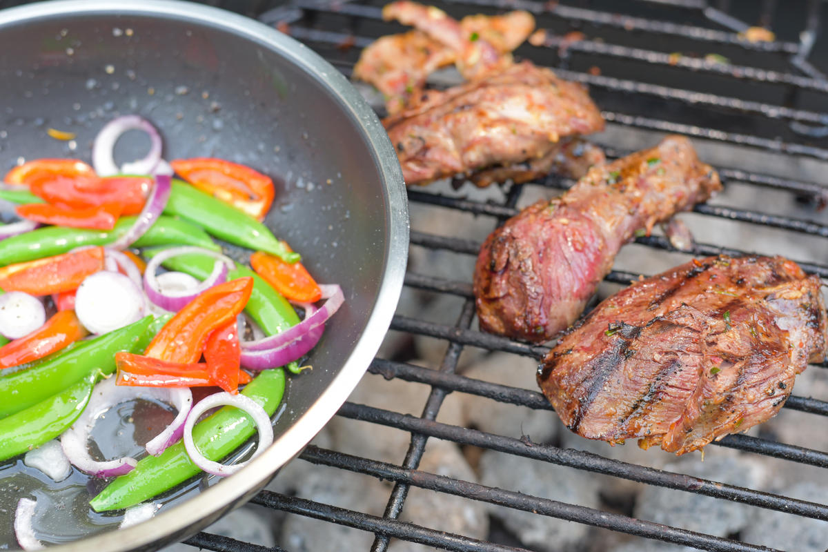 Die Stockentenbrust bei direkter Hitze grillen, Schoten, Paprika und Zwiebel in einer feuerfesten Pfanne  erhitzen.  (Quelle: Kapuhs/DJV)