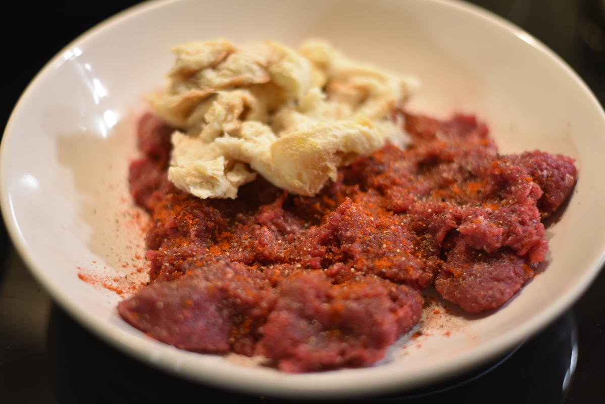 Damwildhack mit Salz, Pfeffer und Paprika würzen. Das Brötchen auswringen und unter das Fleisch mischen.  (Quelle: Kapuhs/DJV)