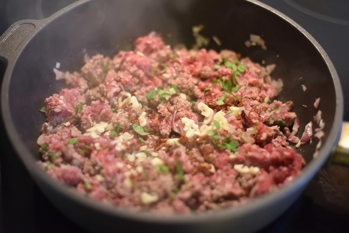 Zuerst Zwiebeln dann Hackfleisch anbraten. Anschließend Knoblauch, getrocknete Tomaten und Minze hinzugeben. Mit Salz, Pfeffer, Oregano und Thymian würzen.  (Quelle: Kapuhs/DJV)