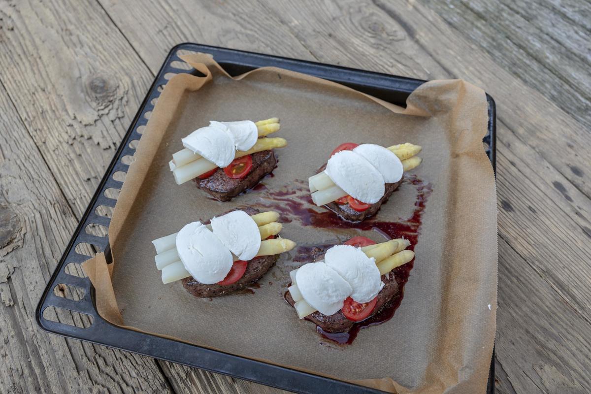 Steaks mit Tomatenscheiben, Spargel und Mozzarella belegen. Im vorgeheizten Backofen 10 – 15 Minuten gratinieren. (Quelle: Dorn/DJV)